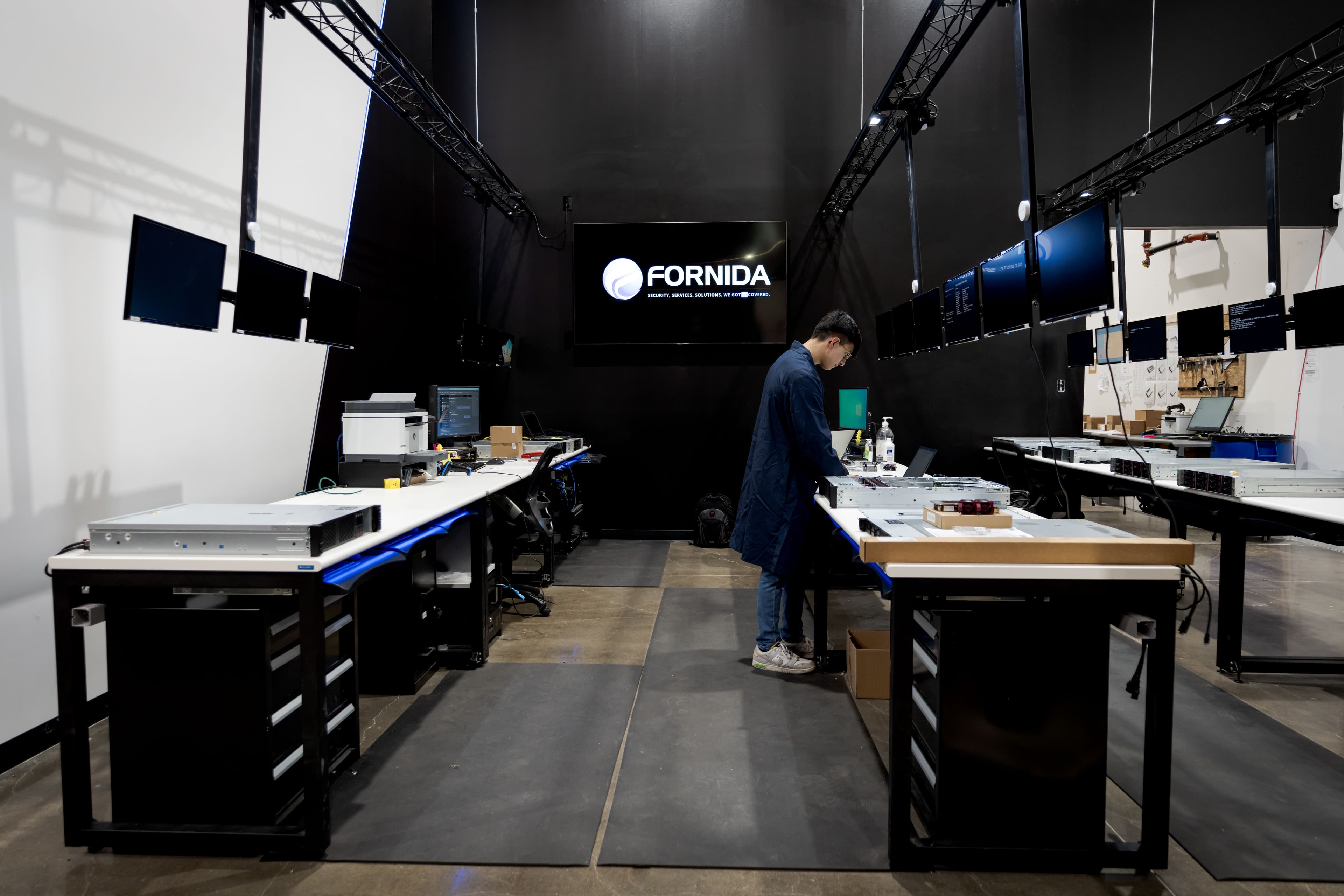 Configuration room with multiple staging benches under a Fornida wall display