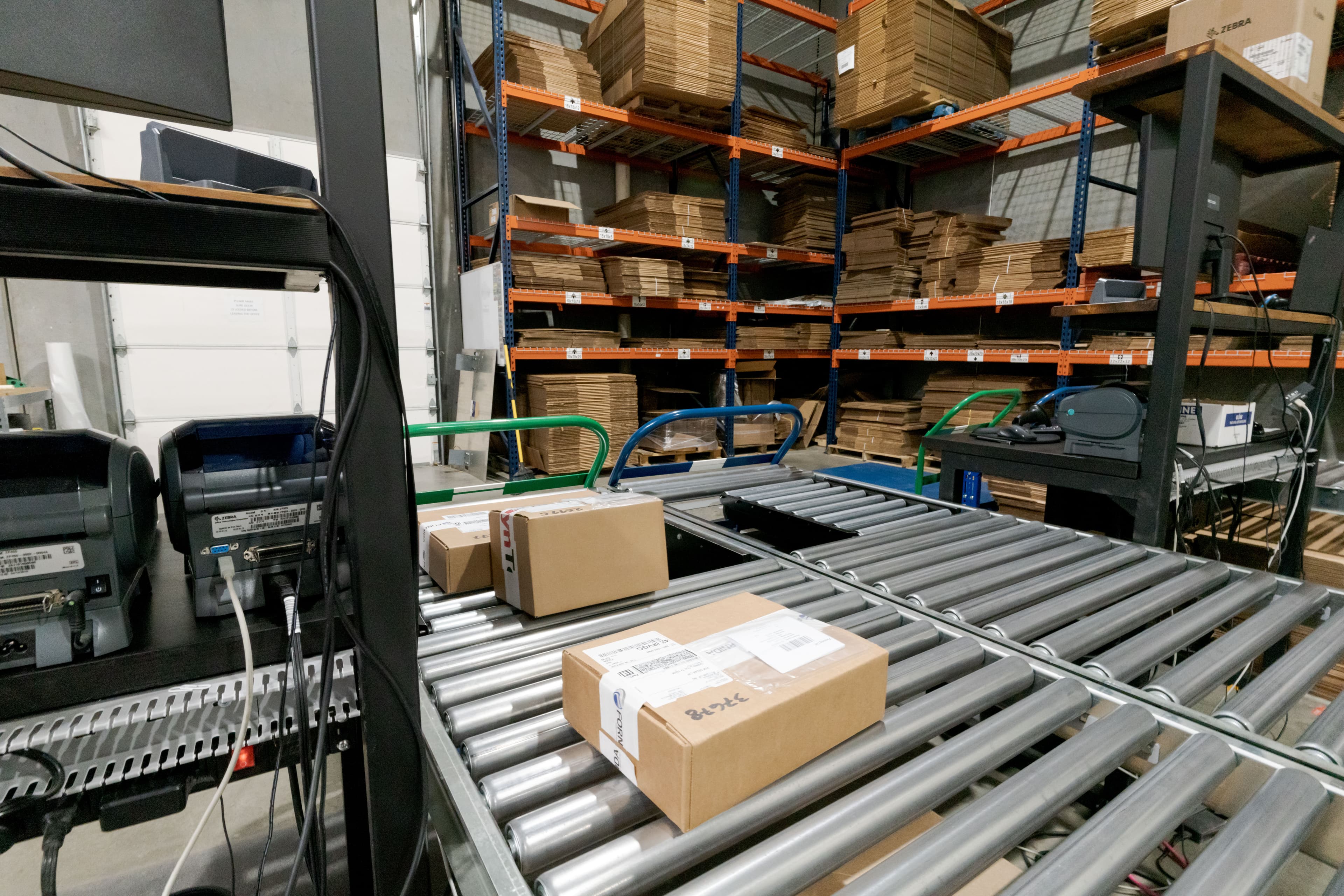Conveyor and packing area with Fornida-branded boxes and labeling stations
